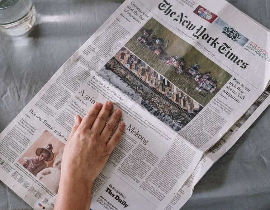person reading newspaper on table